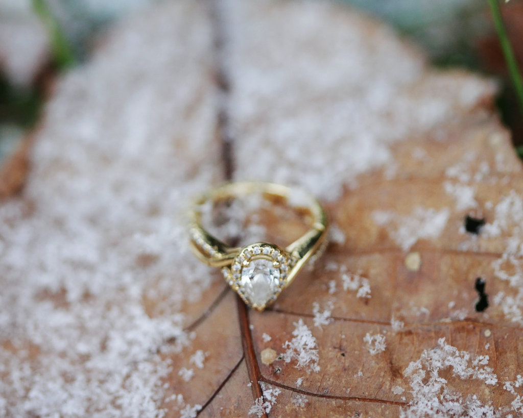 pear shaped diamond engagement ring on snow covered leaf